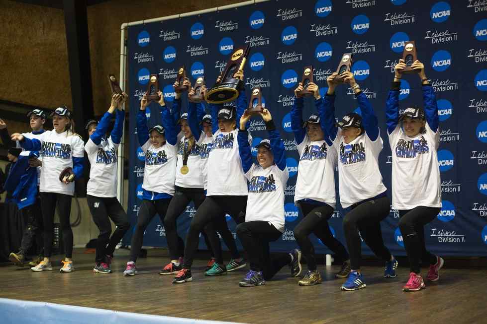 The Laker womens cross country team holds NCAA Division II championship trophies.